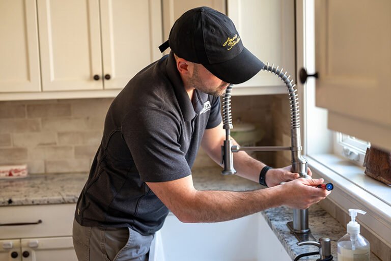 Plumber repairing a kitchen faucet